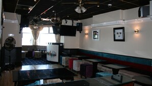 A restaurant with booths, tables, and a ceiling fan. - Blenheim Mount Hotel (Blackpool)