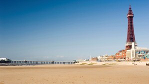 A coastal scene with a prominent tower, a pier, and a sandy beach. - Blenheim Mount Hotel (Blackpool)