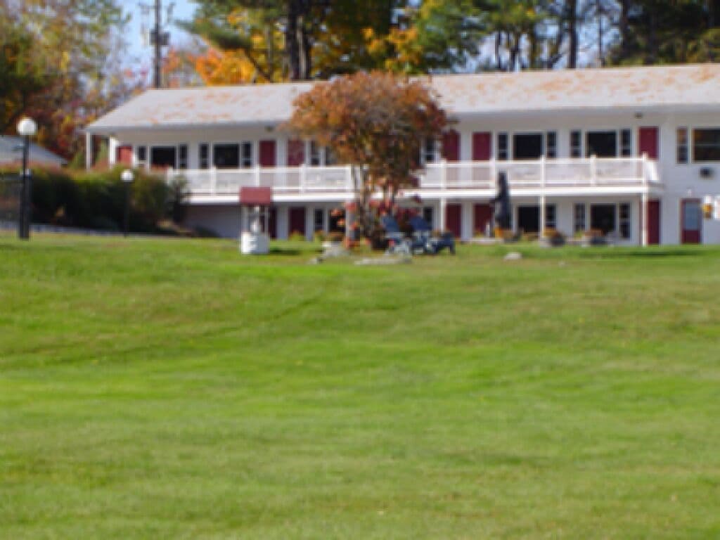 A two-story building with a flat roof and a front porch.