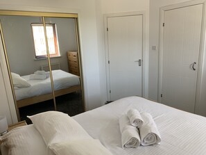 Un dormitorio con una cama, un aparador y dos puertas.