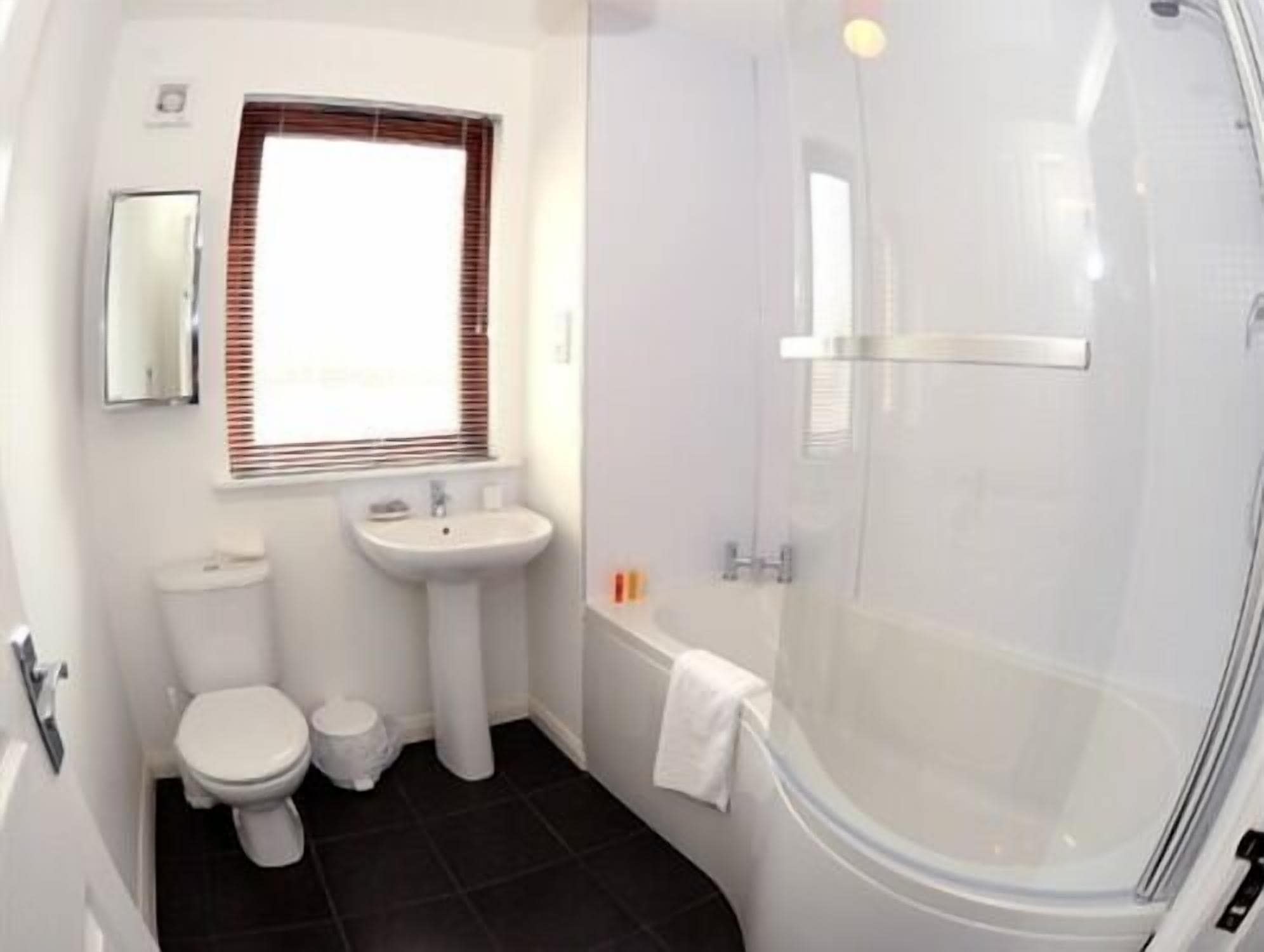 A bathroom with a toilet, sink, and shower.