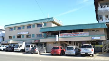 Un edificio con un letrero para un centro de servicios de salud y un estacionamiento con varios autos.