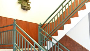Un escalier avec des rampes vertes et des marches en bois.