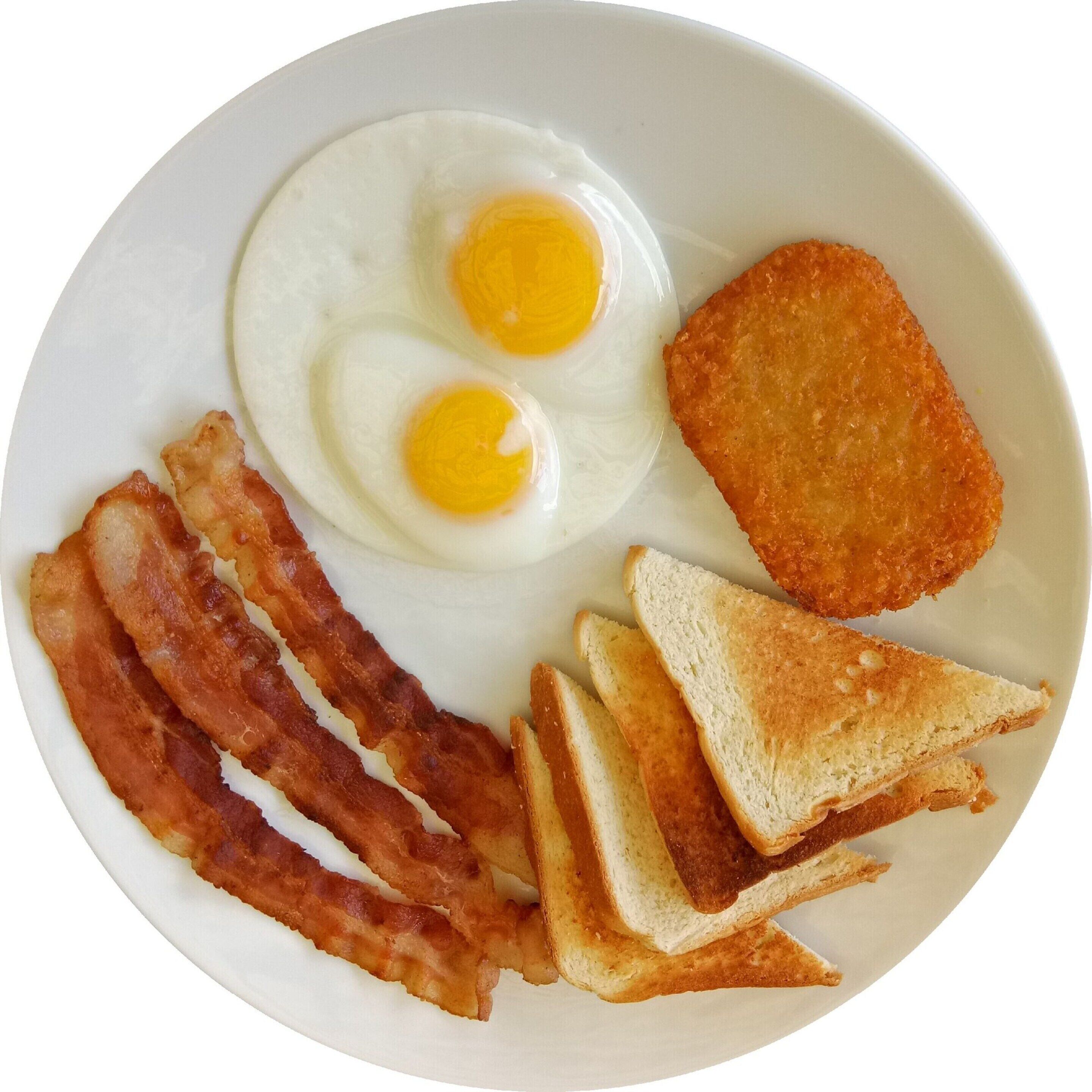A plate with two sunny-side-up eggs, a hash brown, several strips of bacon, and toasted bread.