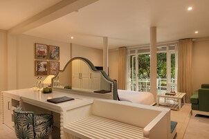 Una habitación de hotel con una cama, un escritorio con espejo, una silla y una pequeña mesa con lámpara.