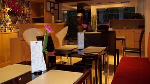 A hotel reception area with a reception desk, chairs, and a plant. - Paradiso Boutique Suites (Bangkok)