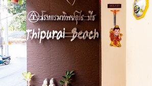 Señal de la playa Thippurai con detalles decorativos y una estatua de Buda.