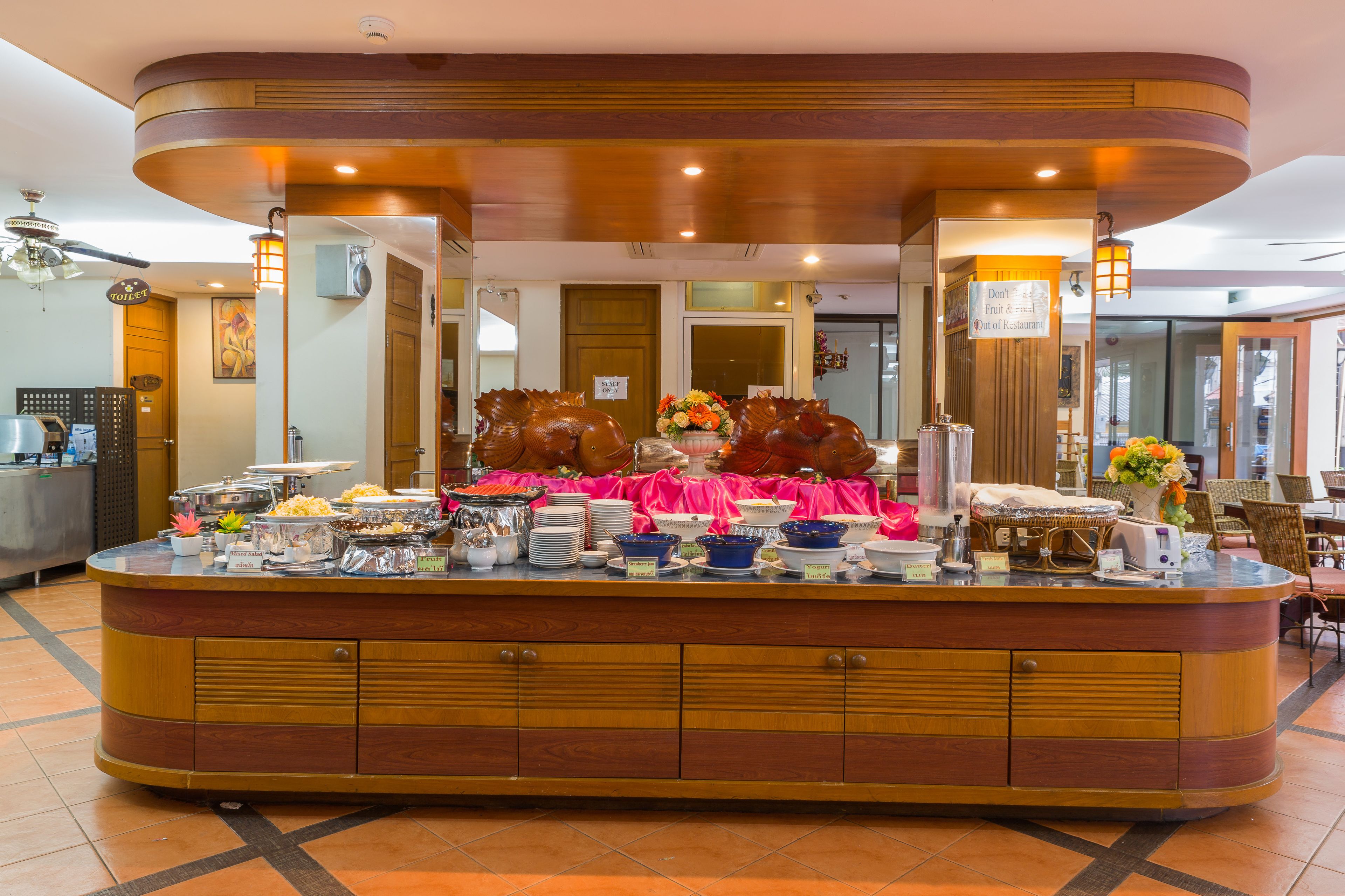 Un buffet proposant divers plats, avec un panneau indiquant qu’il n’y a ni fruits ni légumes au menu.