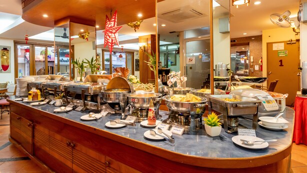Un mostrador de buffet con distintas estaciones de comida, un espejo y una estrella decorativa roja.