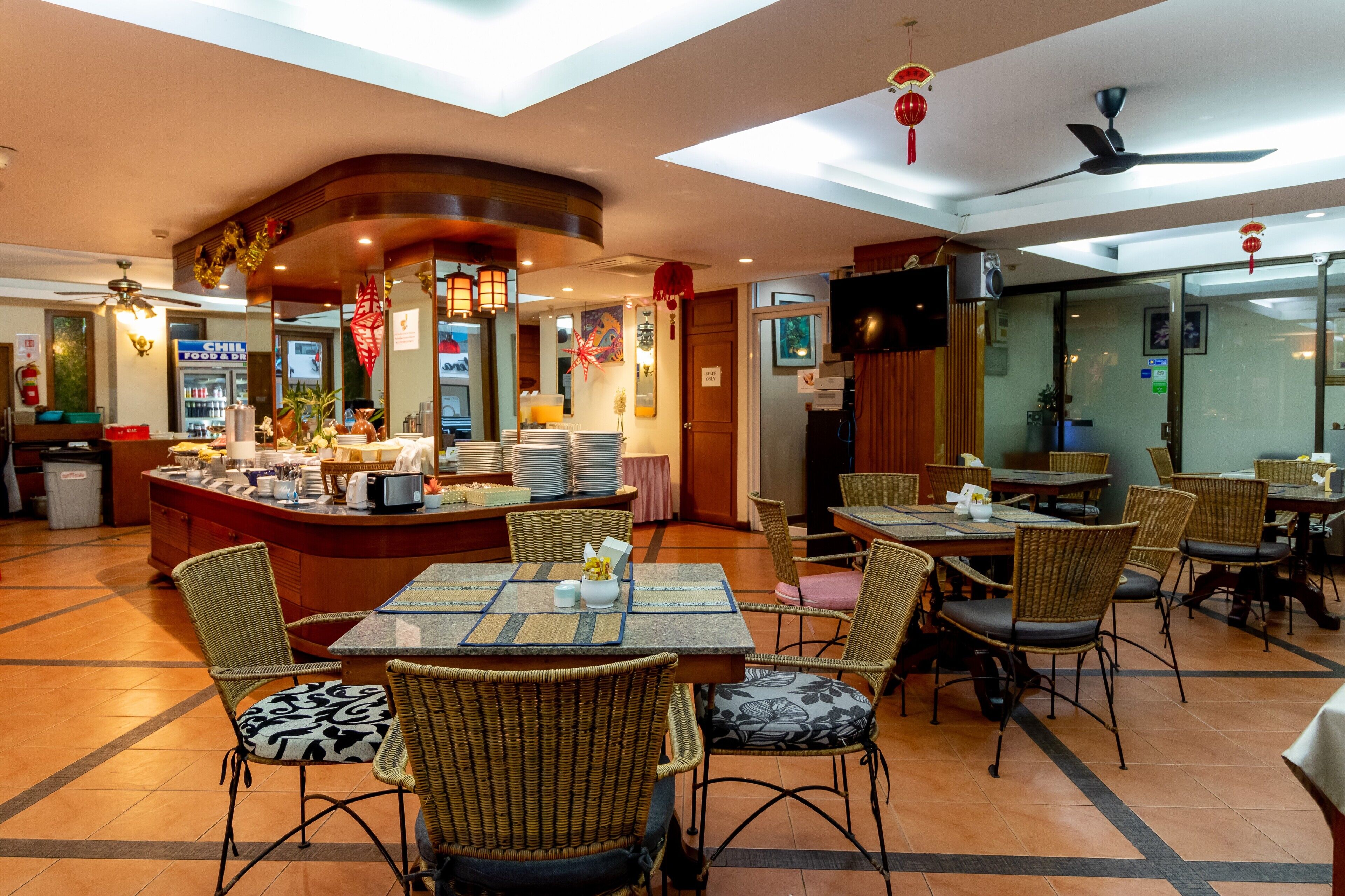 Un restaurante con una isla central, sillas de mimbre y mesas.