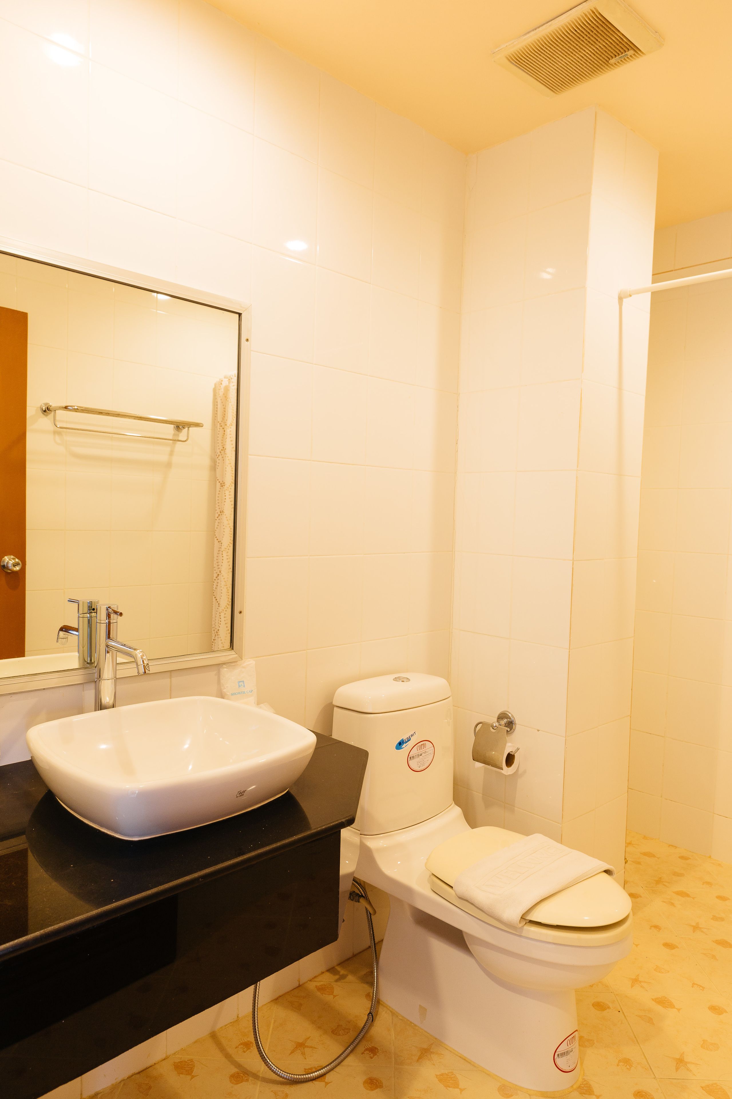 A bathroom with a white sink, a toilet, and a mirror.