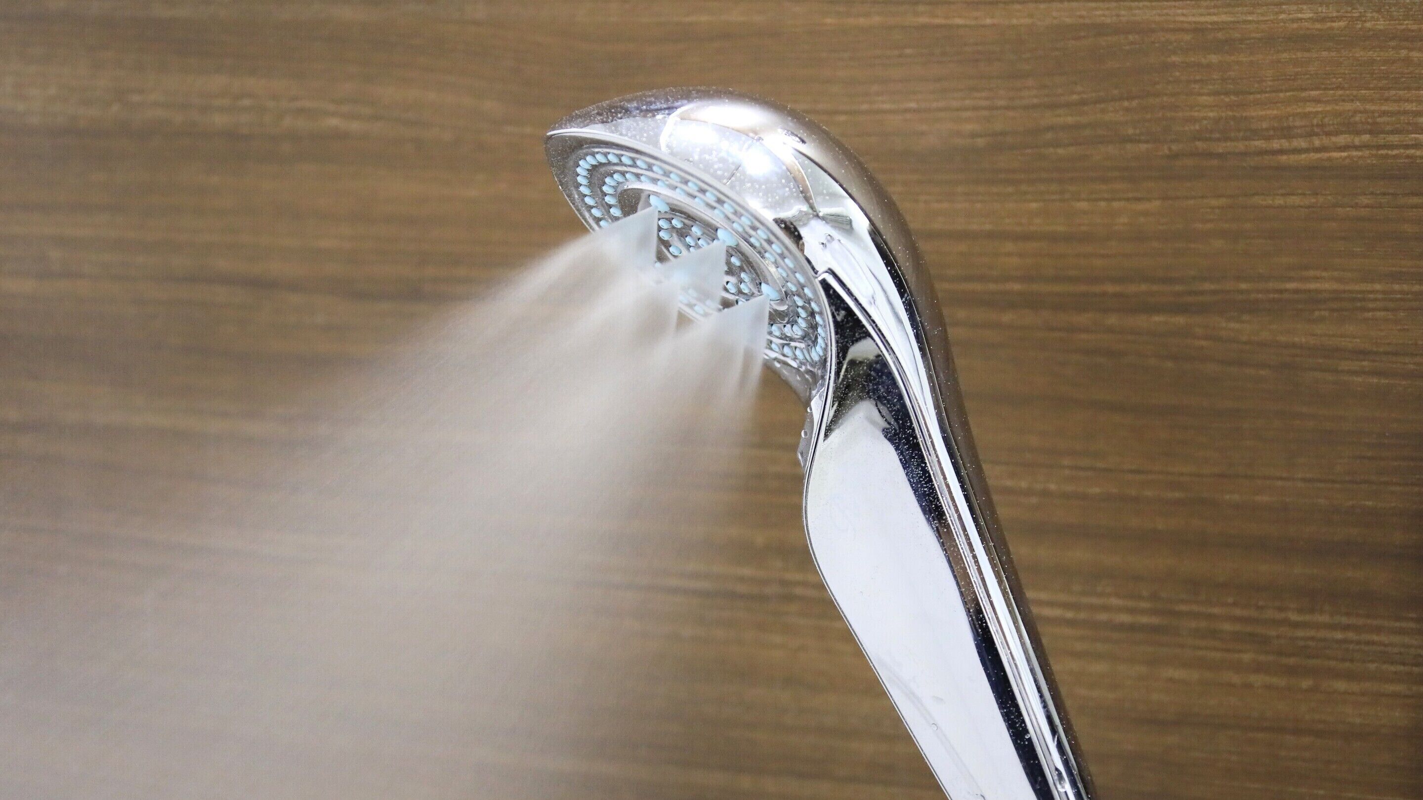 A showerhead with water flowing from it.