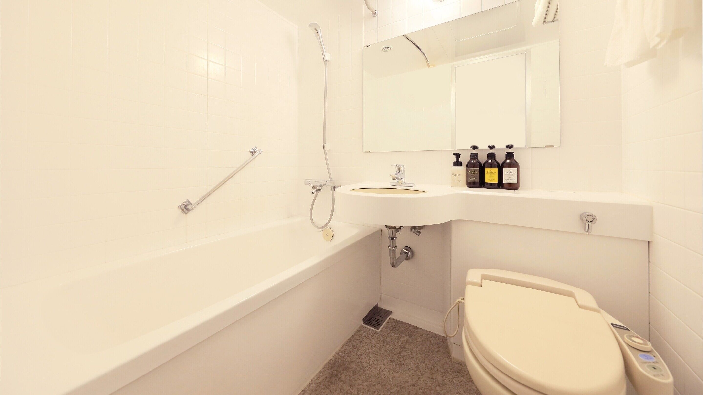 A bathroom with a bathtub, toilet, sink, and a mirror above the sink.