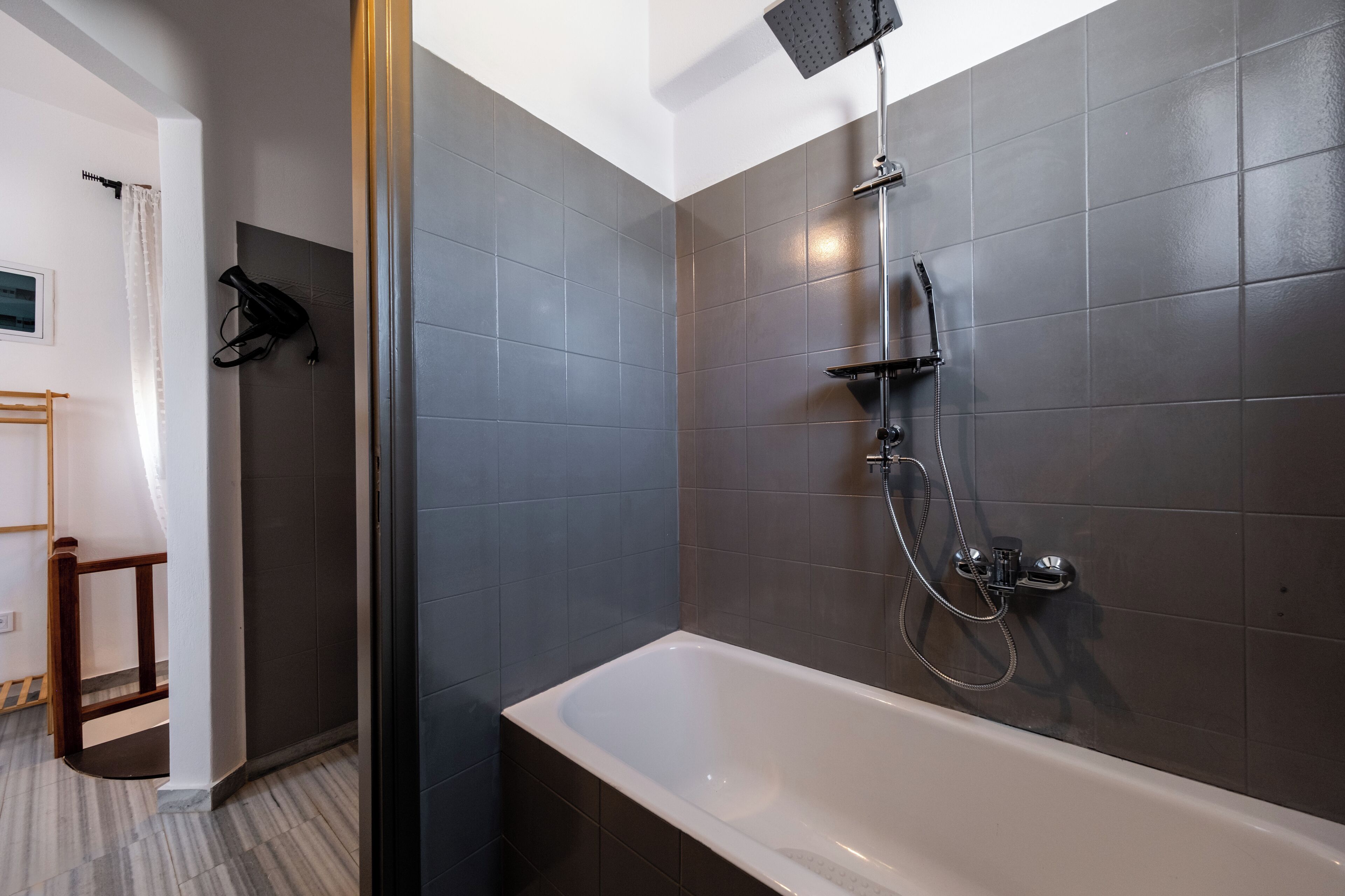 Une salle de bain moderne avec une baignoire, une douche et des murs carrelés.