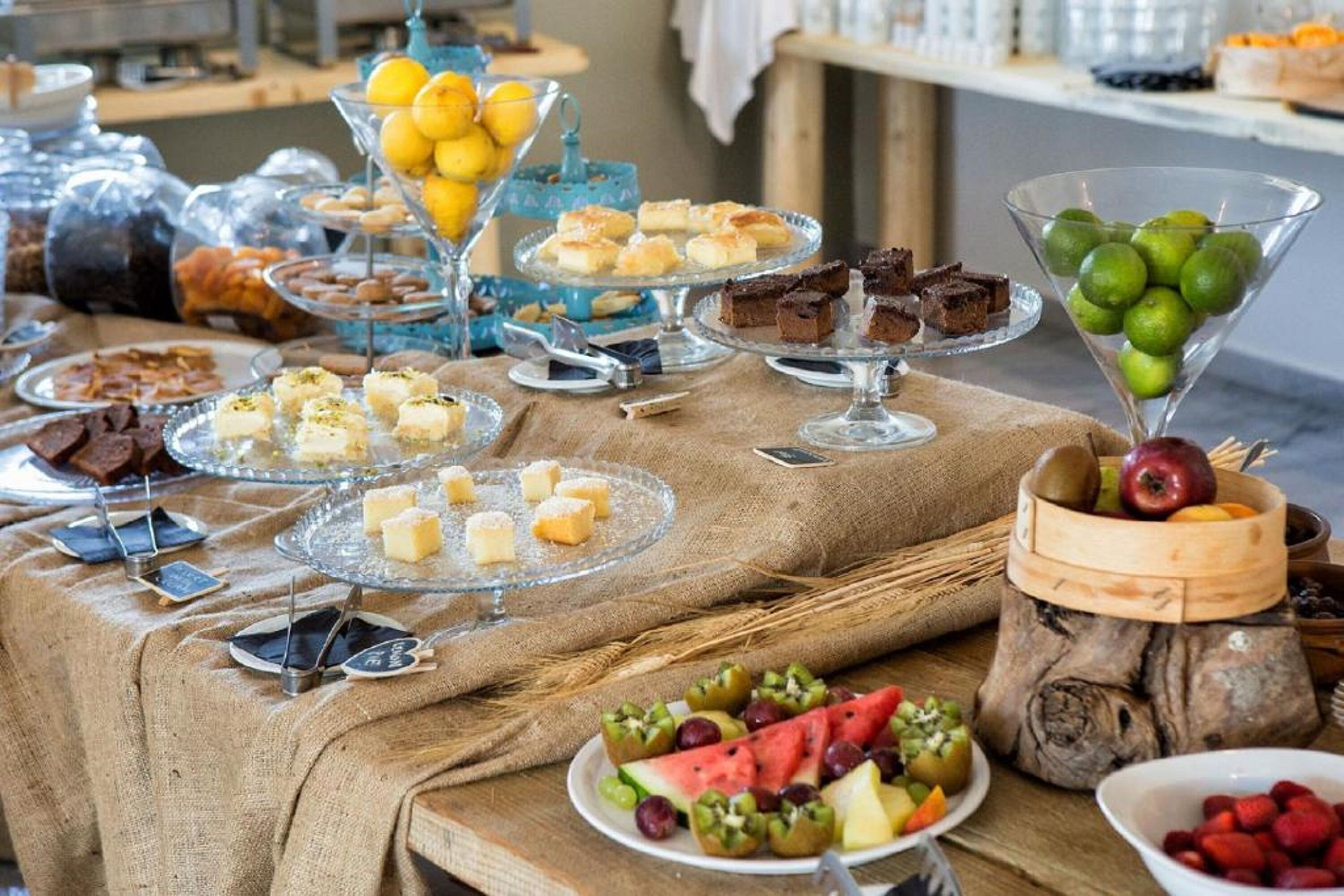 A buffet table with various food items including fruits, desserts, and pastries.