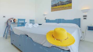 Un dormitorio con una cama, un sombrero amarillo y un cuadro en la pared.