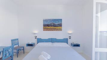 Ein Hotelzimmer mit einem Bett, zwei Nachttischen, einem Schreibtisch mit Stuhl und einem Bild an der Wand.