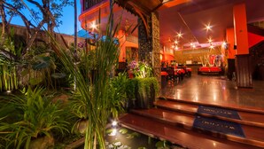 A hotel lobby with a reception desk, seating area, and decorative plants. - Golden Butterfly Villa (Siem Reap)