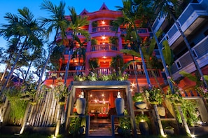 A multi-story hotel with balconies, palm trees, and a well-lit entrance. - Golden Butterfly Villa (Siem Reap)
