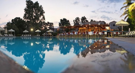 Una piscina al aire libre de temporada, sombrillas