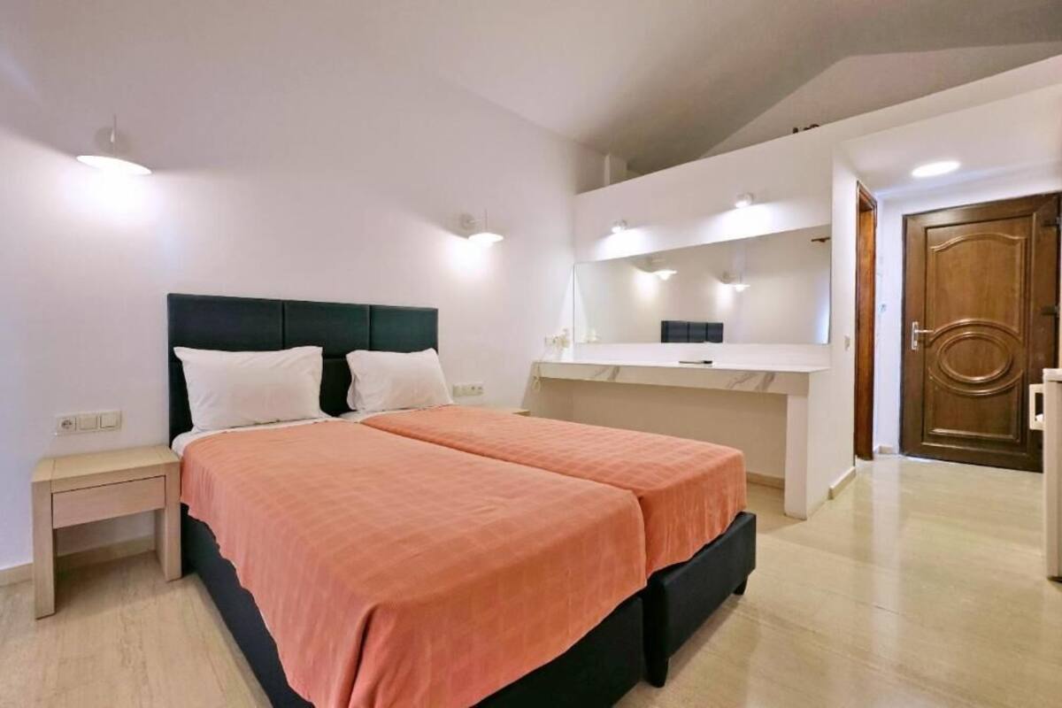 A bedroom with a double bed, a bedside table, a mirror, and a wardrobe.