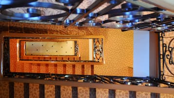A staircase with a patterned wall and a metal railing.
