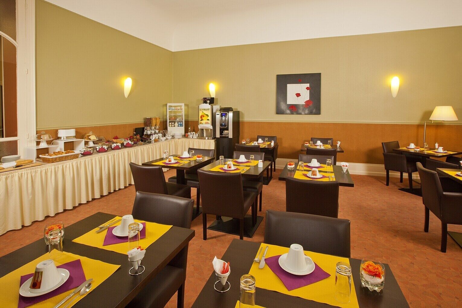 A dining area with tables set for meals, a buffet line, and wall-mounted light fixtures.