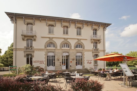 A historic building with a cafe patio, outdoor seating, and a sign indicating it's a tourist residence.