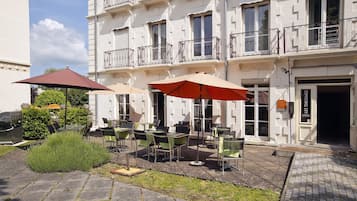 Un patio con mesas al aire libre y acceso a un edificio.