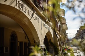 Un hôtel avec une enseigne indiquant « HÔTEL-RESTAURANT GOLDEN GATE ». Il présente un style architectural classique, avec des fenêtres en arc de cercle et des balcons.