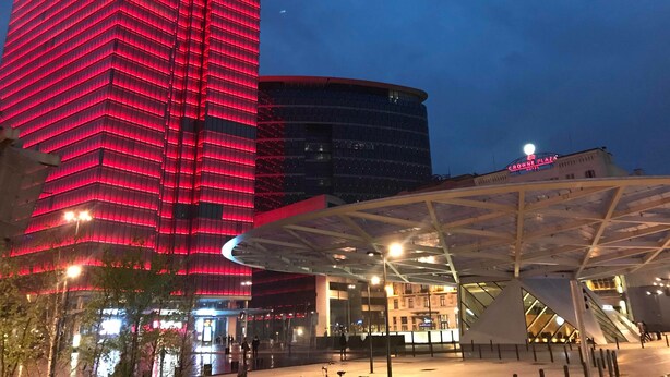A modern hotel with a distinctive red-lit facade, a spacious entrance area, and a prominent glass structure. - Royal Hotel (Brussels)