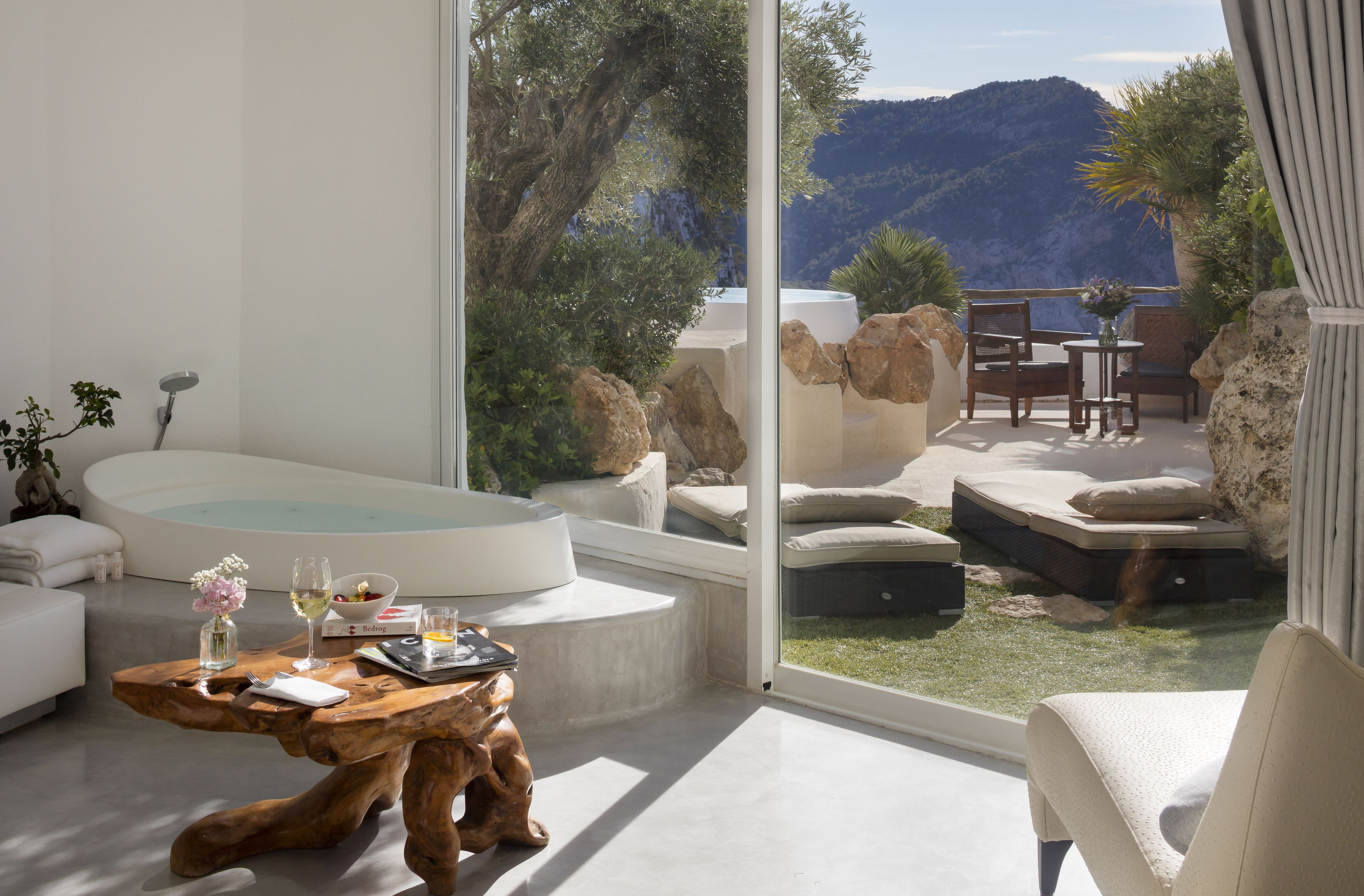 Un espace spa moderne doté d’un bain à remous, de sièges et offrant une vue sur les montagnes.