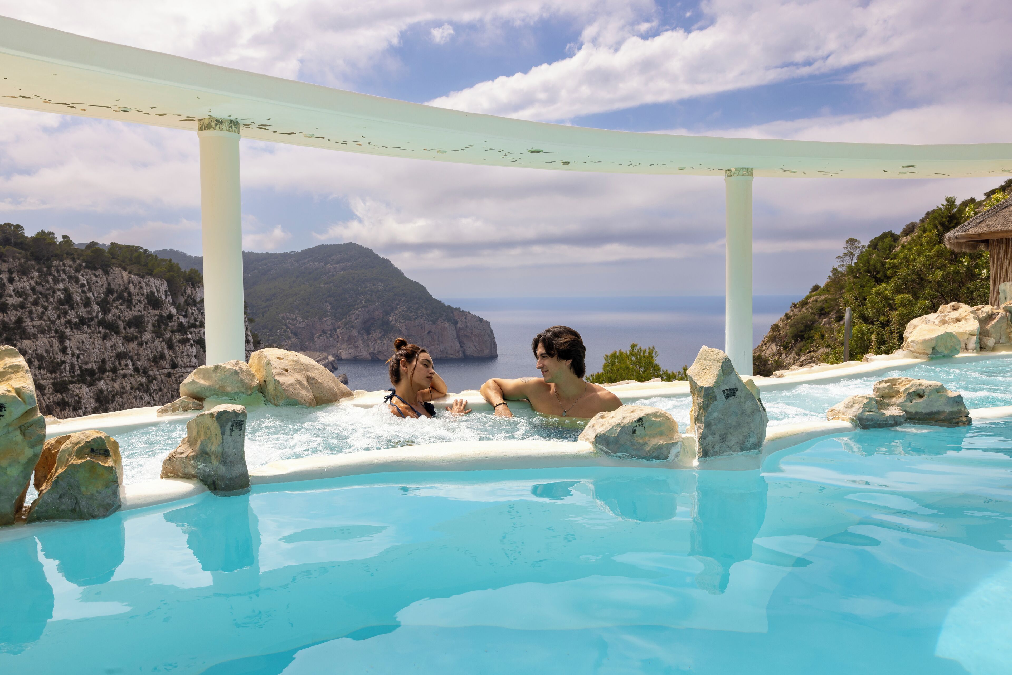 Un jacuzzi con vista al océano y acantilados rocosos.