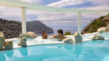 Un jacuzzi con vista al océano y acantilados rocosos.