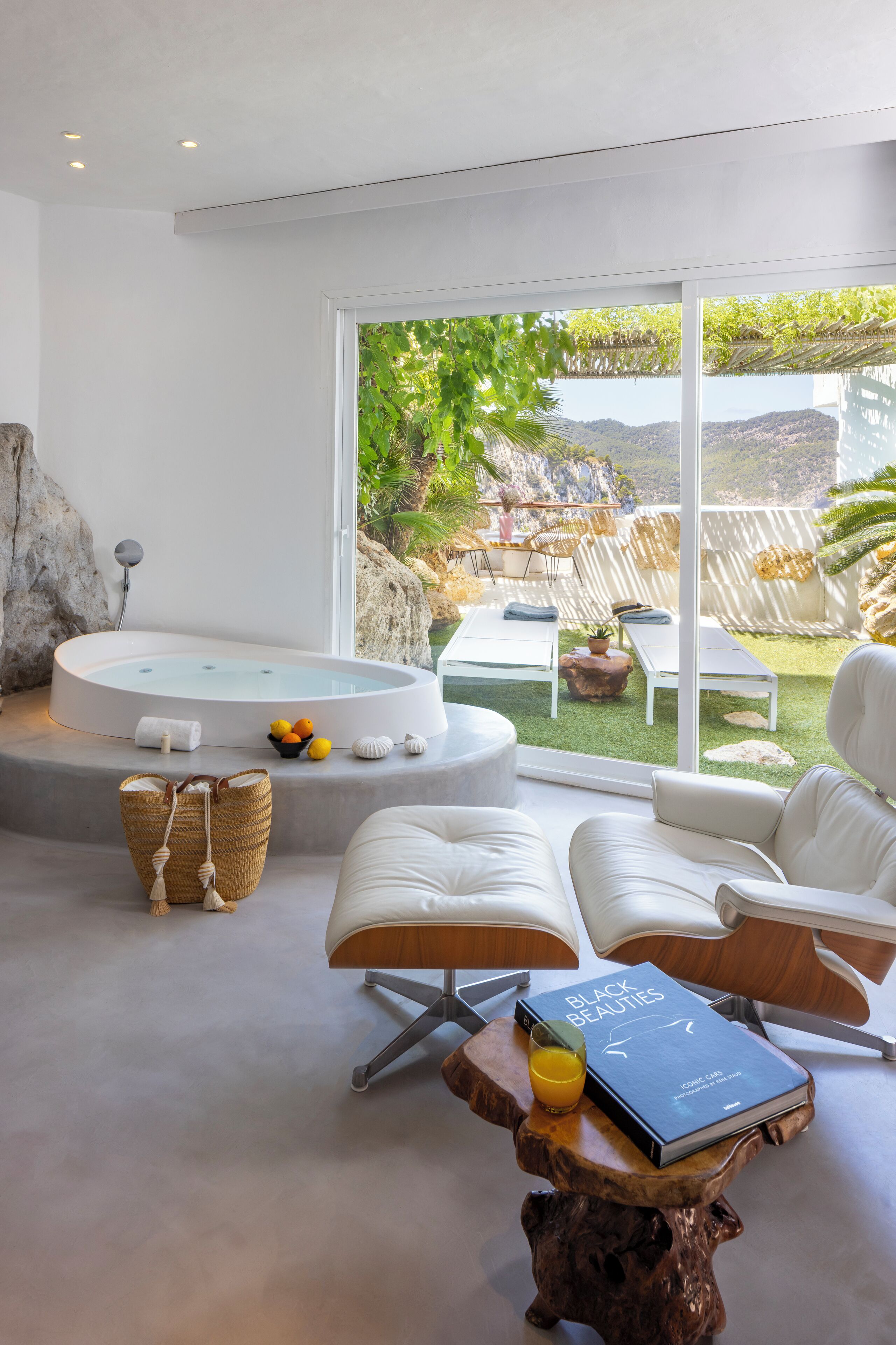 A modern spa area with a hot tub, lounge chairs, and a view of the outdoors.