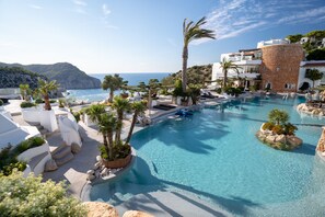 A resort pool area with clear blue water, palm trees, and a view of the sea. - Hacienda Na Xamena, Ibiza (Sant Joan de Labritja)