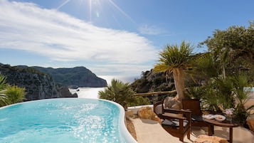 Una piscina privada con vistas al mar y a las montañas.