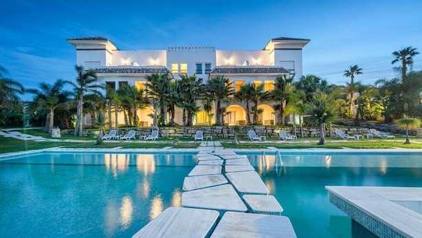 Un hotel moderno y espacioso con piscina y zona de descanso.