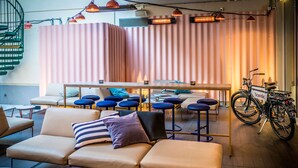 Un'area lounge moderna con un divano, sgabelli da bar e una bicicletta.