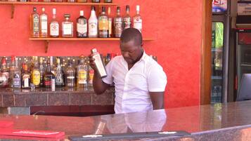 A bar with a variety of liquor bottles on shelves and a person holding a bottle.