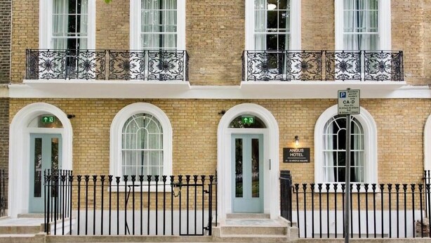 A two-story brick building with a ground-floor entrance and upper-floor windows. - The Angus Hotel (London)