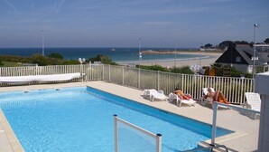 Ein Schwimmbad mit Blick auf den Strand und den Ozean.