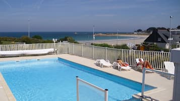 Piscine extérieure, parasols de plage, chaises longues