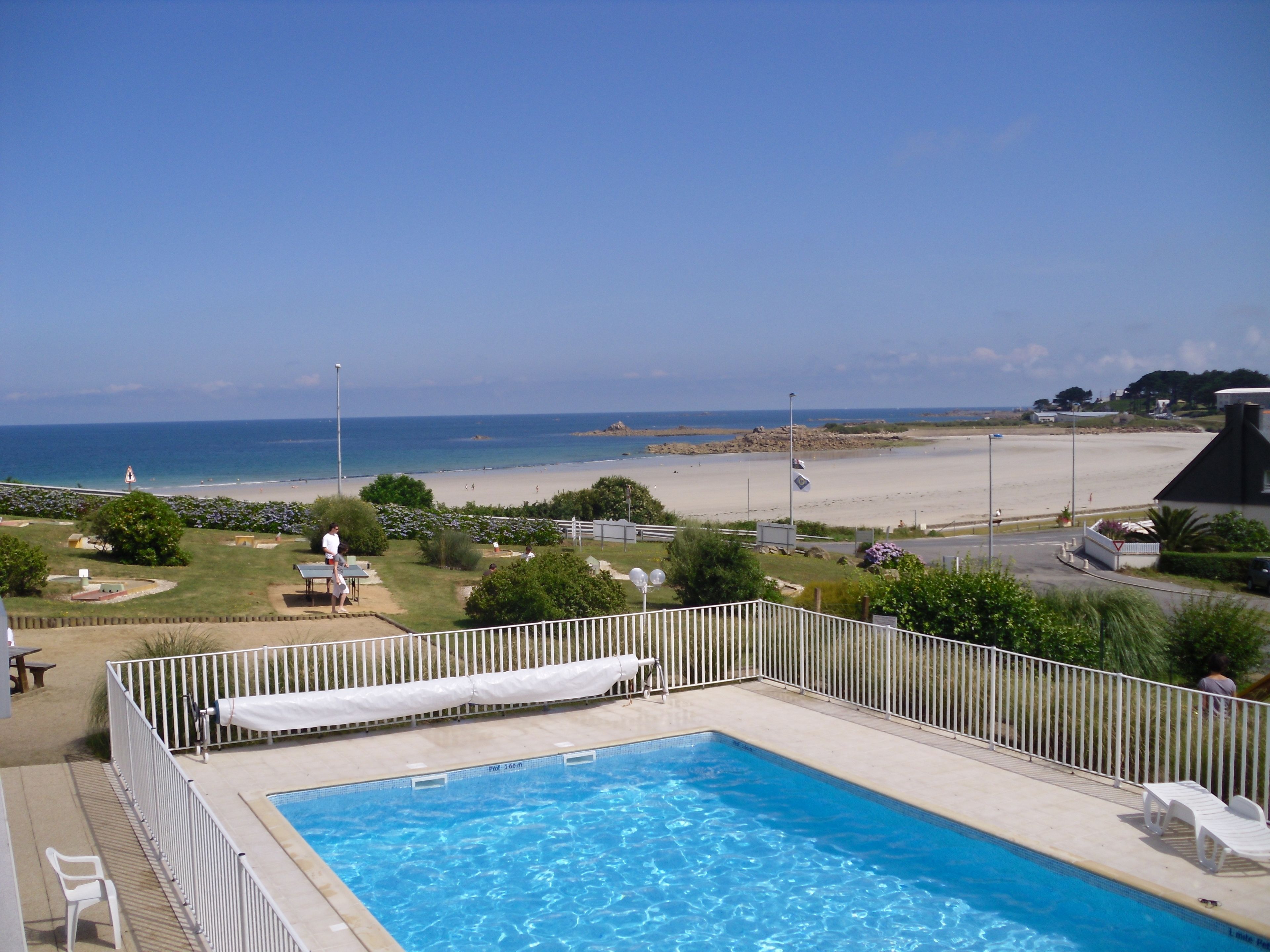Piscina com vista para a praia e oceano.