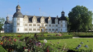 A large, historic building with multiple towers and a well-maintained garden in front. - Best Western Plus Arosa Hotel (Paderborn)