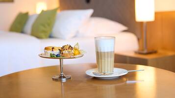 Una mesa de comedor con un plato de muffins y una taza de café.