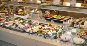 A buffet with various food items and condiments.