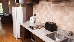 Cuina compacta amb nevera, batedora, torradora i un rentaplat.