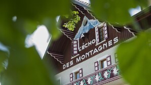 Un bâtiment sur lequel on peut lire l’inscription « LECHO DES MONTAGNES », et qui possède un balcon agrémenté de balustrades décoratives.