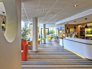 A modern hotel lobby with a striped floor, a bar area, and a seating area with colorful chairs. - ibis Styles Strasbourg Avenue du Rhin (Strasbourg)